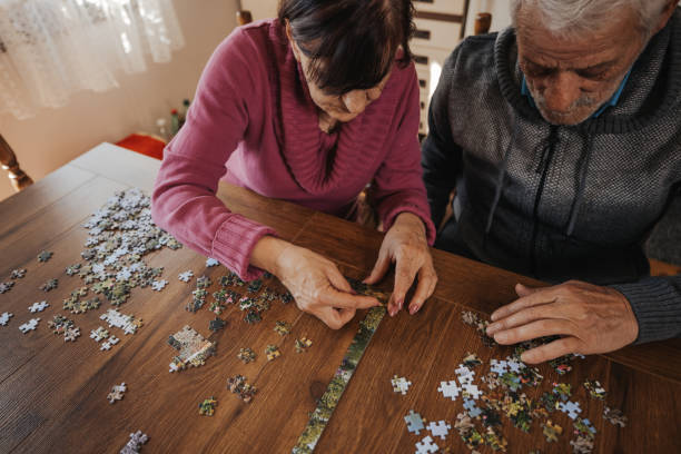istock Concentrated senior couple doing a jigsaw puzzle at home 1335206431