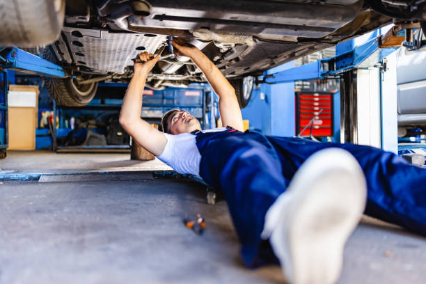 istock Mechanic lying and working under car at the repair garage 1335207064