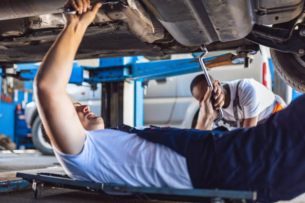 istock Mechanic lying and working under car at the repair garage 1335207068