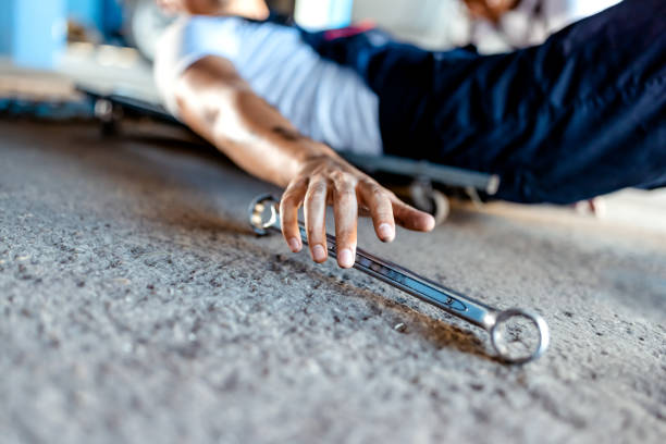 trabajador masculino del mecánico del coche que trabaja usando la herramienta de la llave inglesa para la reparación, mantenimiento por debajo del coche. servicio de vehículos mecánicos comprobando debajo del coche en el garaje. servicio de reparación - adult manual worker automobile industry transportation fotografías e imágenes de stock