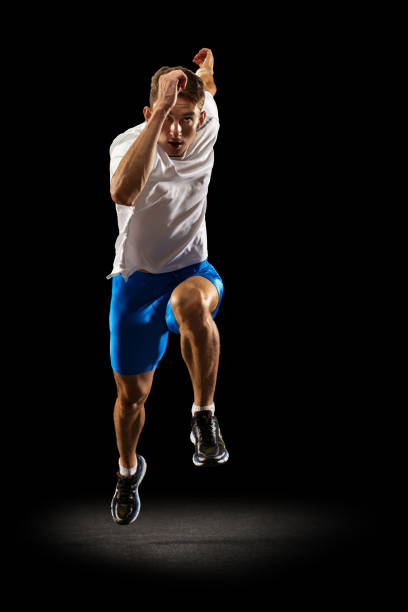 istock Static portrait muscular, sportive man, male athlete, runner training isolated on dark studio background with spotlight. Concept of action, motion, youth, healthy lifestyle. 1335210185