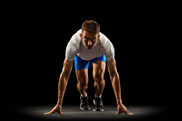 istock Sportive young man, male athlete, runner training isolated on dark studio background with spotlight. Concept of action, motion, youth, healthy lifestyle. 1335210190