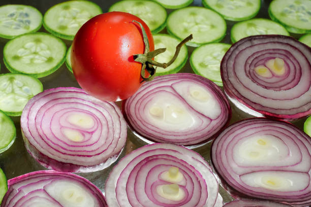 verduras en rodajas, cebollas rojas, pepinos en el primer plano de la mesa - radish vegetable portion circle fotografías e imágenes de stock