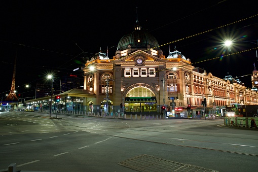 Empty Flinders Street Station in Melbourne's CBD after curfew at night during the covid-19 pandemic lockdown August 2021. The view of an empty intersection Flinders Street and Swanston street