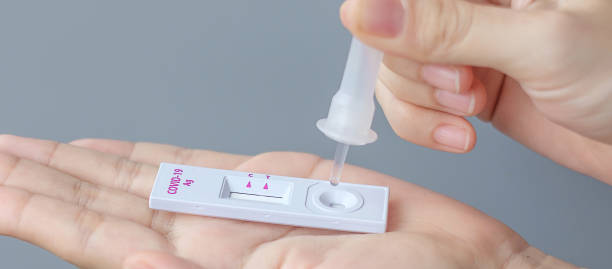 istock man swab COVID-19 testing by Rapid Antigen Test kit. Coronavirus Self nasal or Home test, Lockdown and Home Isolation concept 1335212506