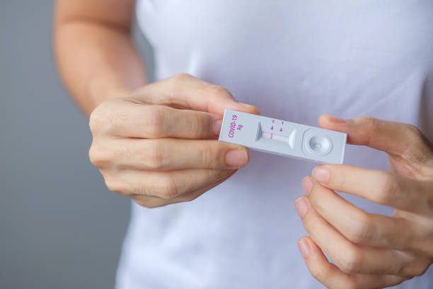 istock man holding Rapid Antigen Test kit with Negative result during swab COVID-19 testing. Coronavirus Self nasal or Home test, Lockdown and Home Isolation concept 1335212722