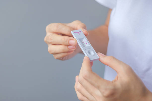 istock man holding Rapid Antigen Test kit with Negative result during swab COVID-19 testing. Coronavirus Self nasal or Home test, Lockdown and Home Isolation concept 1335212726