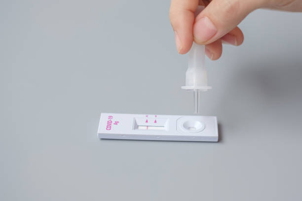 istock man swab COVID-19 testing by Rapid Antigen Test kit. Coronavirus Self nasal or Home test, Lockdown and Home Isolation concept 1335213358