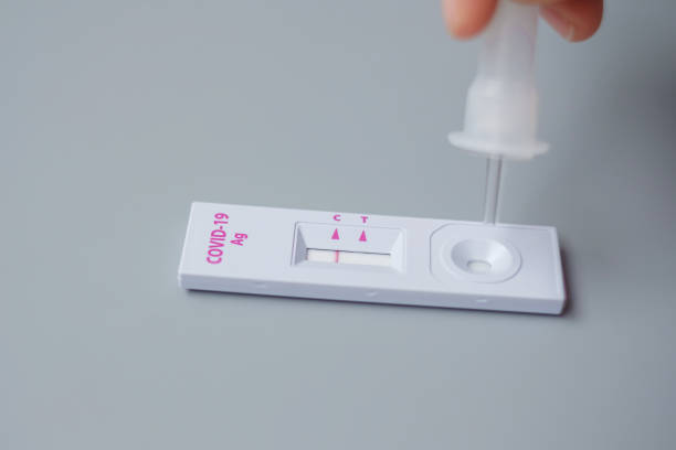 istock man swab COVID-19 testing by Rapid Antigen Test kit. Coronavirus Self nasal or Home test, Lockdown and Home Isolation concept 1335213415