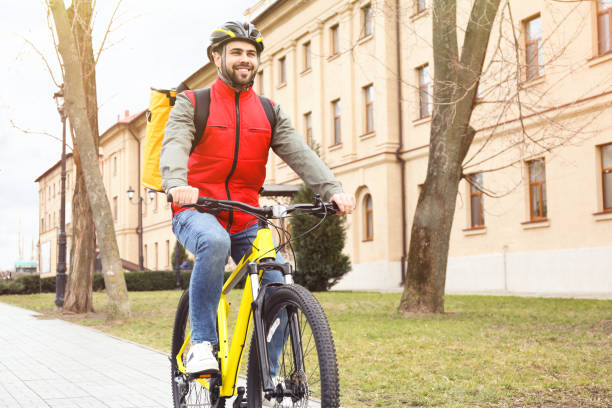 istock Courier with thermo bag riding bicycle outdoors. Food delivery service 1335215336