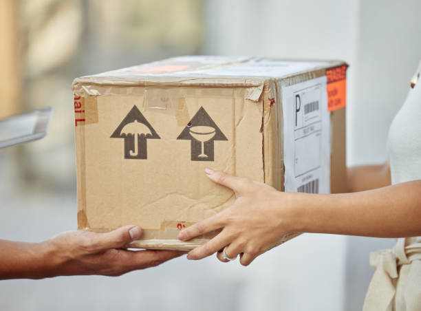 istock Shot of a delivery man passing a package to a customer 1335223318