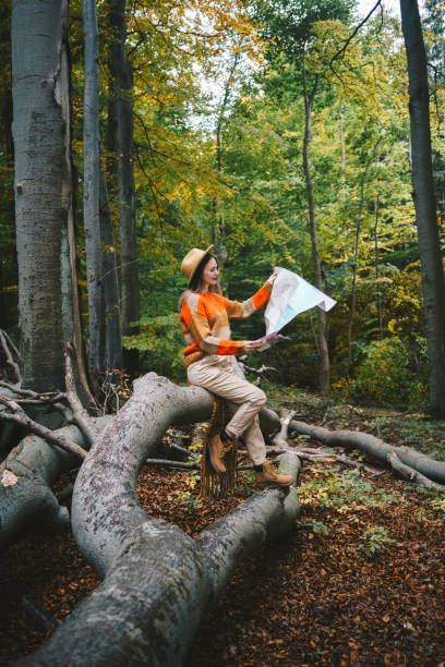 Woman posing in the forest with a paper map