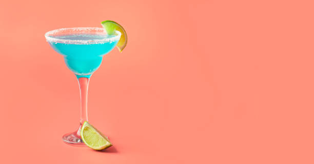 istock Blue cocktail with tequila, liqueur, lime juice, salt and ice, pink background, negative space 1335229141