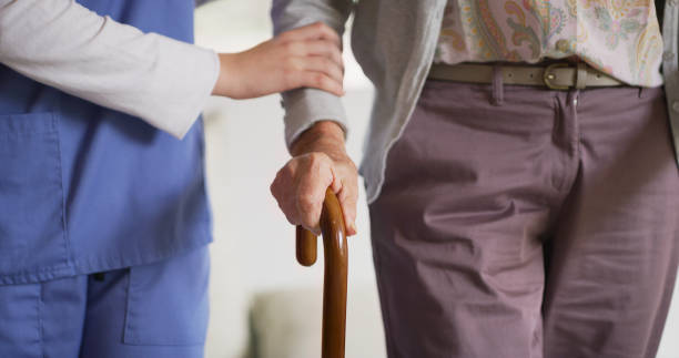 istock Shot of a nurse helping her elderly patient use her walking stick 1335229877