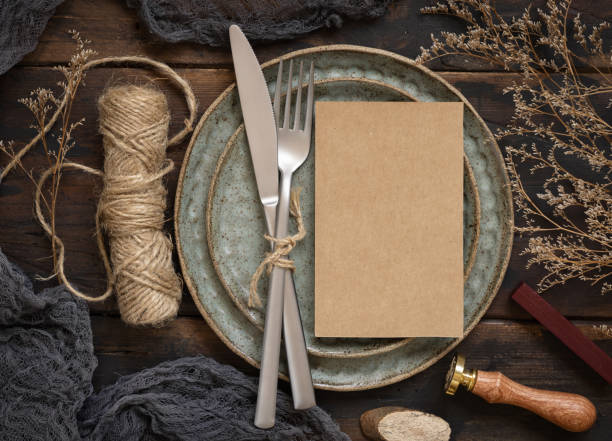 istock Blank paper card on plate with fork and knife and dried plants 1335232060