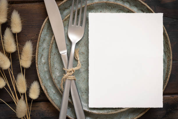 istock Blank paper card on plate with fork and knife and dried plants 1335232065