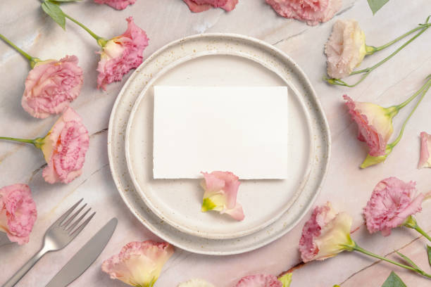 istock Blank paper card on a plate with pink flowers on a marble table 1335232086