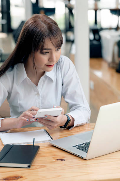 istock pretty accountant working with computer and calculator while sitting at her office desk 1335232734