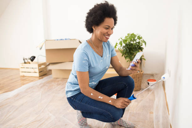 istock Beautiful Afro woman checking on the DIY tutorial how to paint walls at home 1335233739