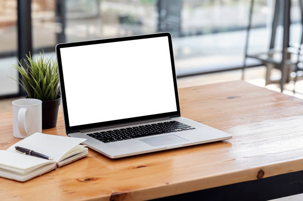 istock Laptop computer with blank screen on wooden table in office room. 1335233919