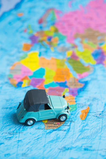 istock retro car on colorful world map, travel 1335234108