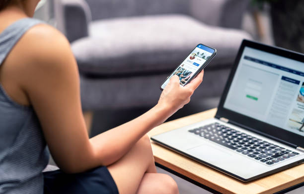 página de perfil de redes sociales en la pantalla del teléfono inteligente en el trabajo. mujer mirando feed, actualización de estado o post con teléfono móvil. trabajador perezoso ineficiente que evita el trabajo. - myspace fotografías e imágenes de stock