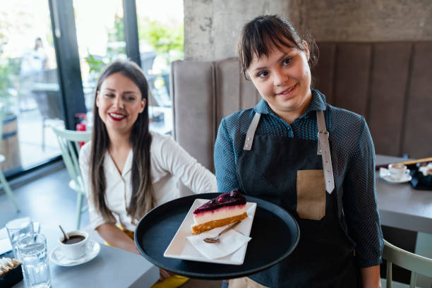 istock Young woman with Down Syndrome working at cafe 1335236593