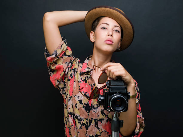 istock Young beautiful woman posing with a medium format film camera, studio shot 1335236758