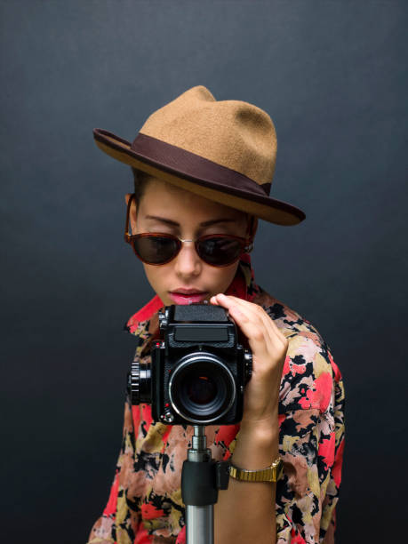 istock Young beautiful woman posing with a medium format film camera, studio shot 1335236783