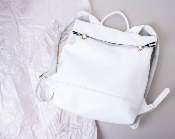 istock White handmade leather backpack on gray background and crumpled paper 1335236929