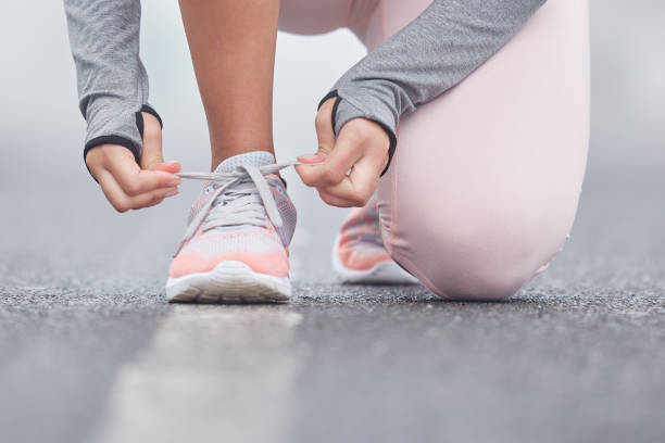 istock Closeup shot of an unrecognizable persn tying their shoelaces while exercising 1335237593