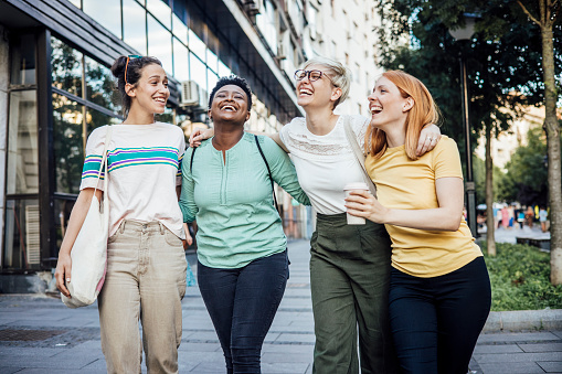 Group of teenage girls walking down the street, having fun and enjoying their friendship.