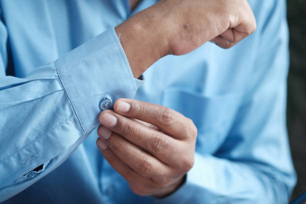 istock Man buttoning his shirt close up 1335238841