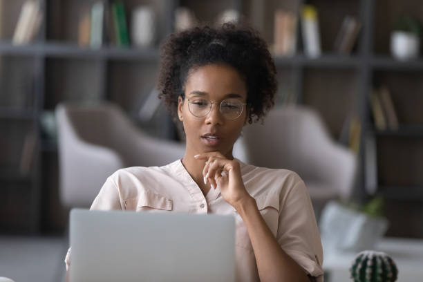 istock Pensive African American woman work on laptop thinking 1335240347
