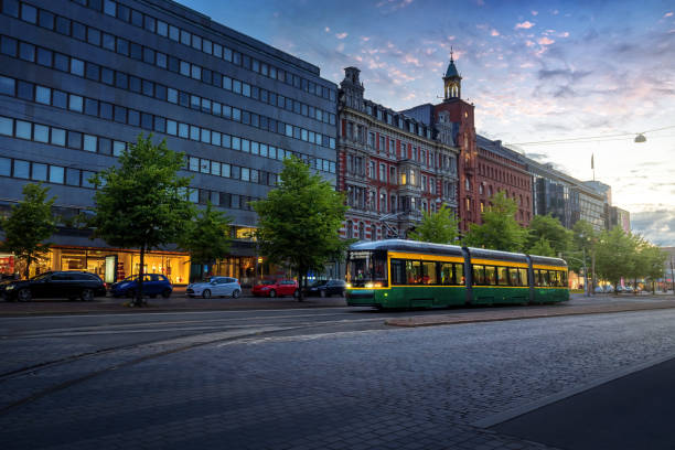 city tram in mannerheimintie street bei sonnenuntergang - helsinki main street im stadtzentrum - helsinki, finnland - urban scene street car nobody stock-fotos und bilder