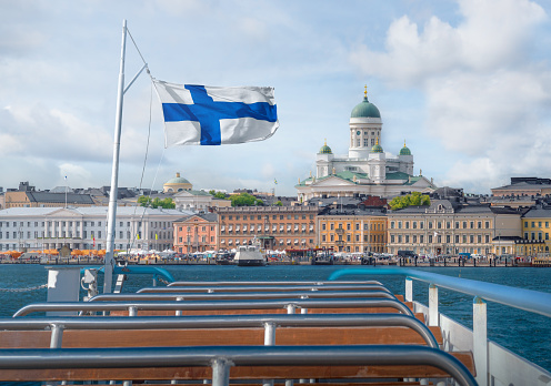 Vista en barco del horizonte de Helsinki con bandera finlandesa y catedral de Helsinki - Helsinki, Finlandia photo