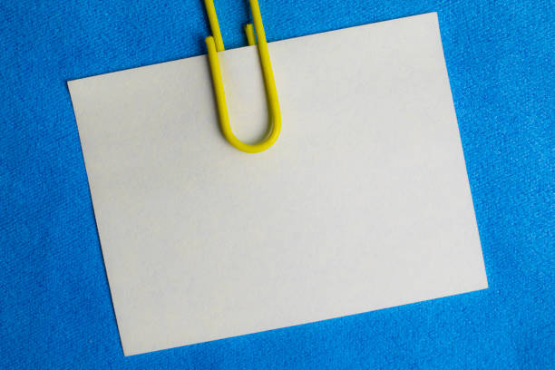 istock white blank note pinned to a blue notice board with a paper clip. 1335242587
