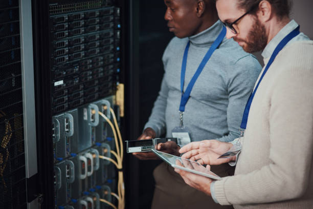 istock Shot of two young technicians using a digital tablet in a server room 1335243523