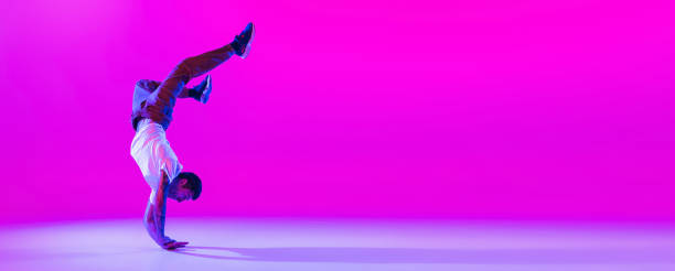 istock Flyer with dancing man, break dancer in action, motion in modern clothes isolated over bright magenta background at dance hall in neon light. 1335243811