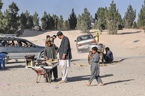 Kabul Afghanistan 05.10.2012: Man with market stall cart selling corn and beverages on the hills of Kabul City