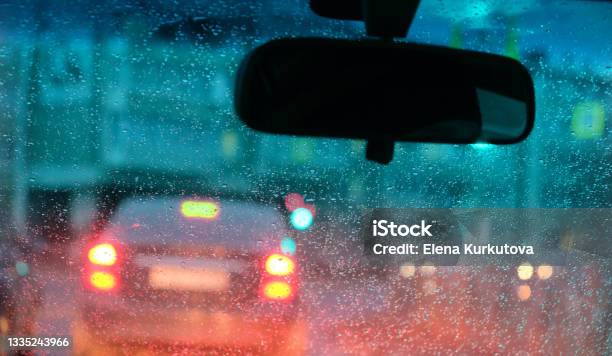 Motion Blurred Night City Lights Illuminated Streets Through Fogged Up In Small Drops Car Windshield Stock Photo - Download Image Now