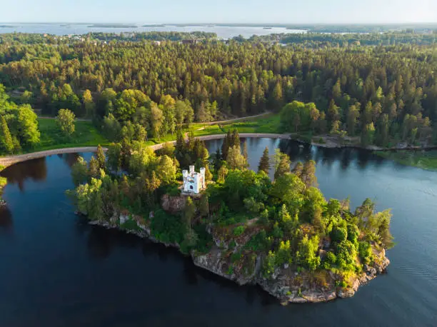 Aerial landcape view of Monrepos park in Vyborg city. Summer, green forest, island, castle, blue sky