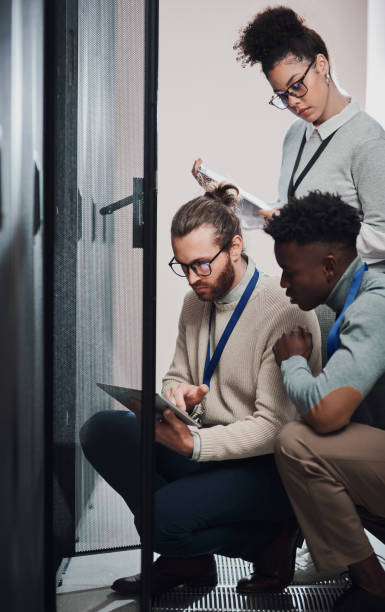 istock Shot of a group of technicians using a digital tablet in a server room 1335246932