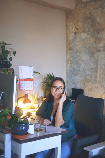 istock Shot of an attractive young woman sitting alone and using her cellphone while working from home 1335249714