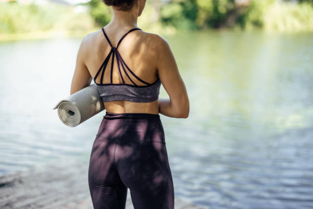 istock Young woman, holding a yoga mat. 1335251004
