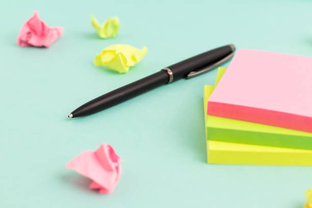 istock Empty colorful sticky note paper with pen and crumpled paper on turquoise background. Selective focus. 1335251073