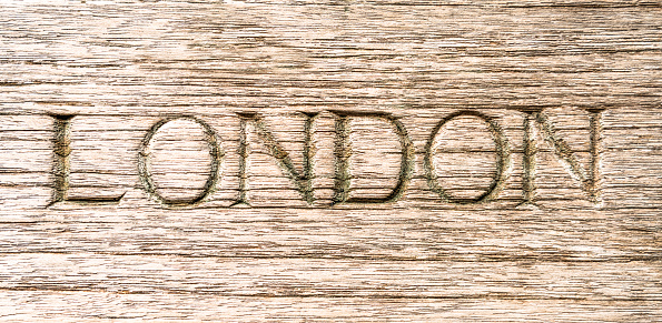 The word 'London', carved into a wooden surface.