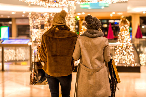 Two Beautiful Women at Winter Shopping in a city decorated with lights