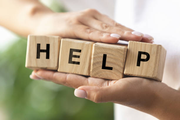 istock Female hands holding wooden cubes, blocks word HELP. Conceptual image about human rights, education, social issues, support, mental health, education and personal development. 1335257509