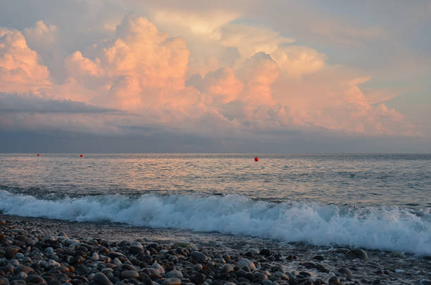 Sunset and surf on the beach with pebbles in the village of Loo, Russia, Krasnodar Territory